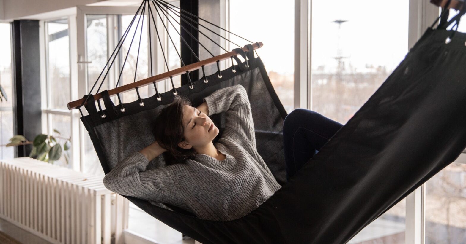 Woman lying in a hammock during indoor camping